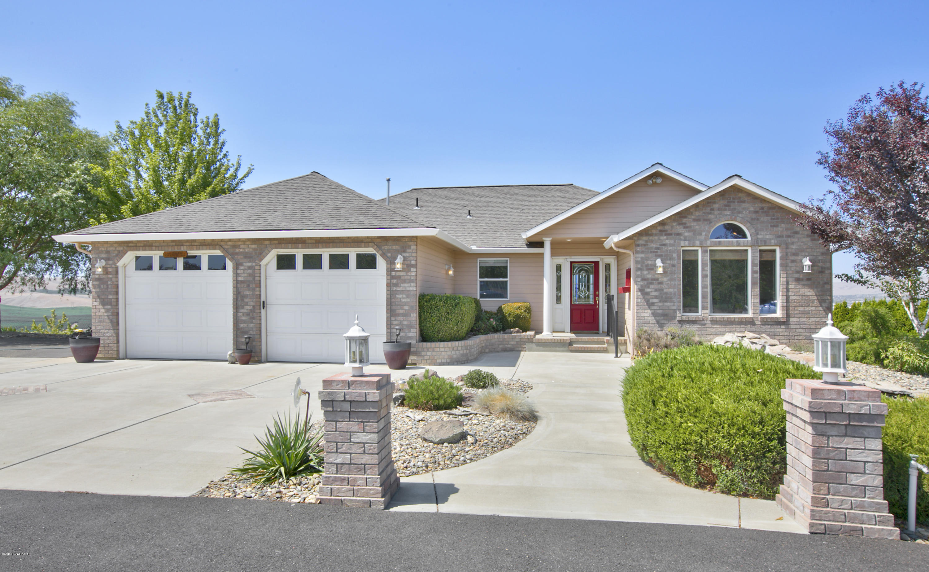 229 Konnowac Pass Road Moxee, WA 98936 - Photo 1 of 25 a front view of a house with a yard and potted plants