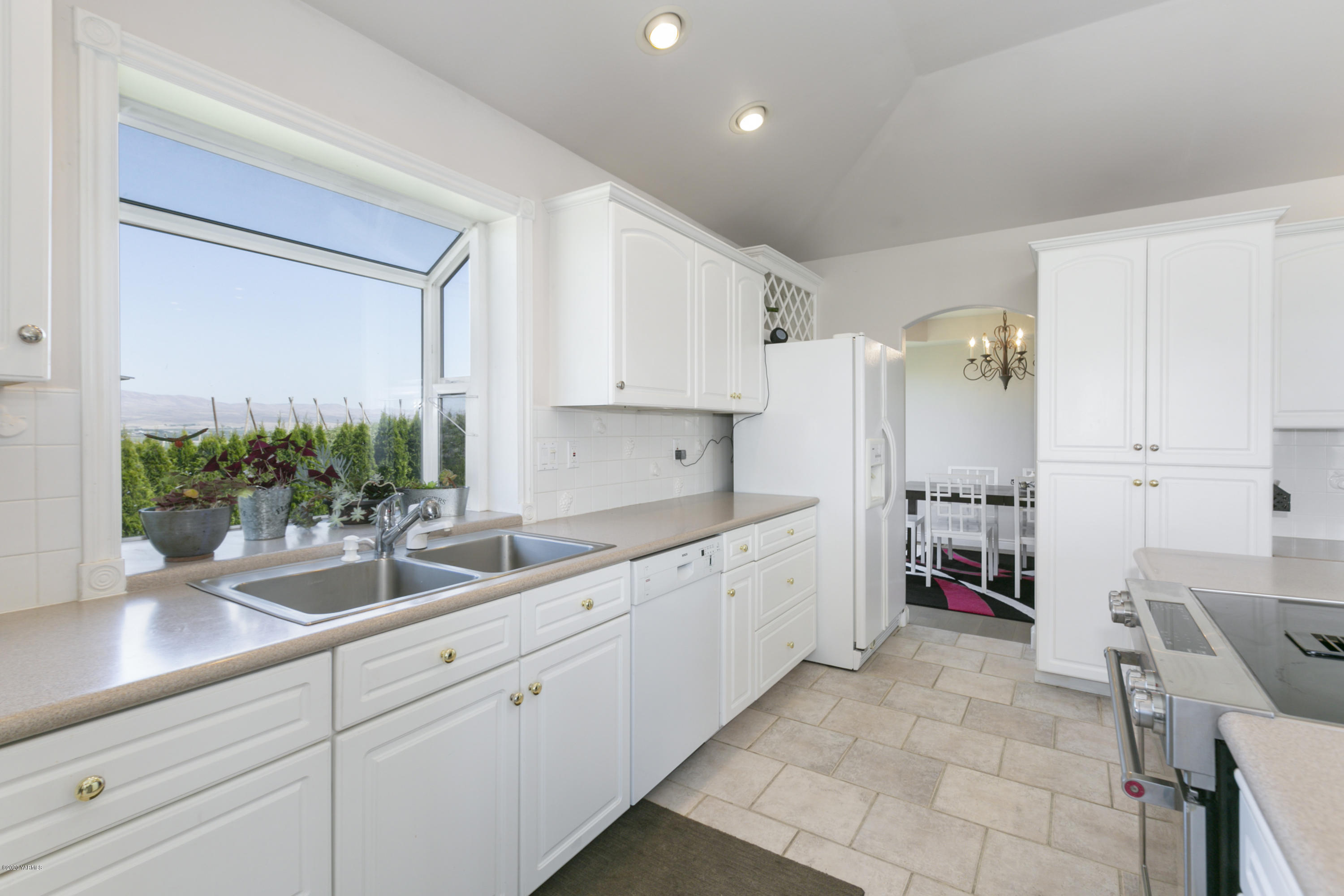 229 Konnowac Pass Road Moxee, WA 98936 - Photo 11 of 25 a kitchen with cabinets a sink and a refrigerator