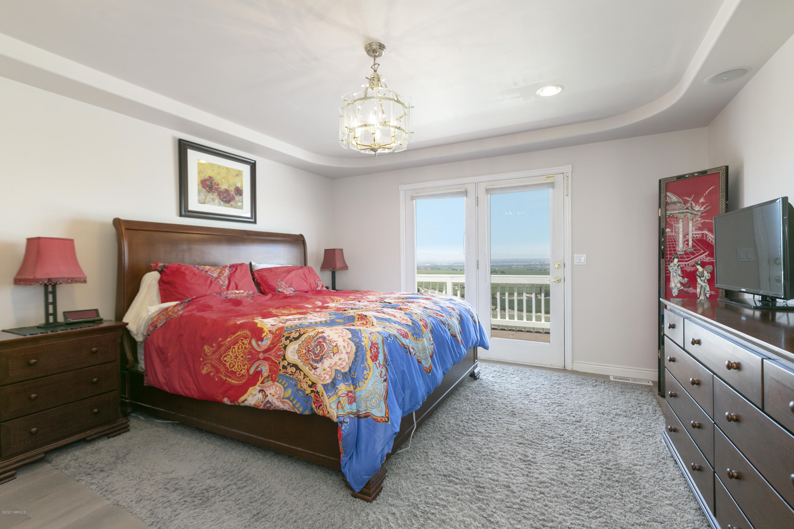 229 Konnowac Pass Road Moxee, WA 98936 - Photo 14 of 25 a spacious bedroom with a bed and a flat screen tv