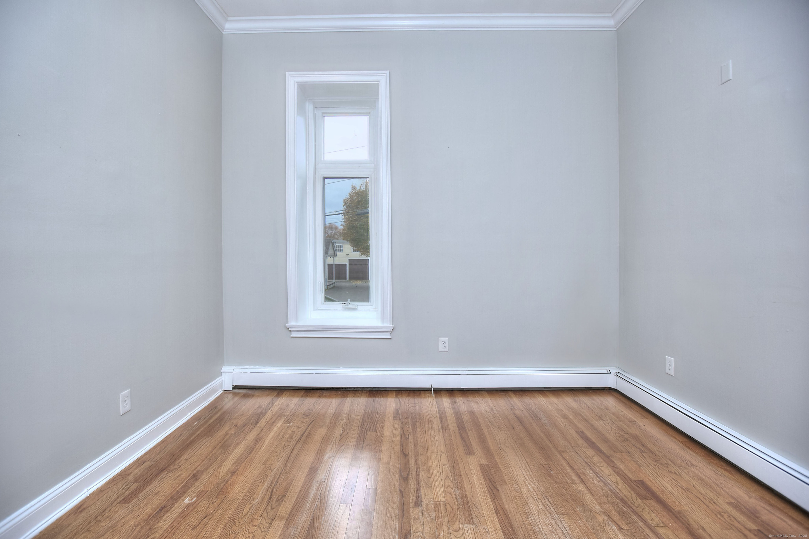 300 Soundview Avenue Fairfield, CT 06825 - Photo 25 of 28 a view of an empty room with wooden floor and a window