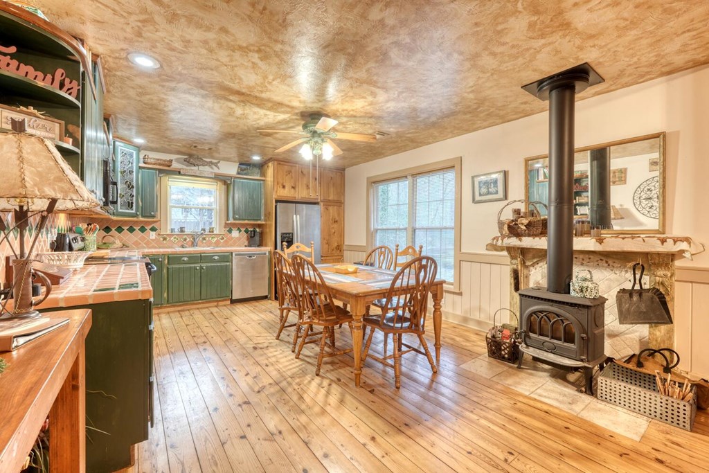 4868 Swallows Creek Road Hiawassee, GA 30546 - Photo 17 of 59 a view of a dining room with furniture a chandelier and wooden floor