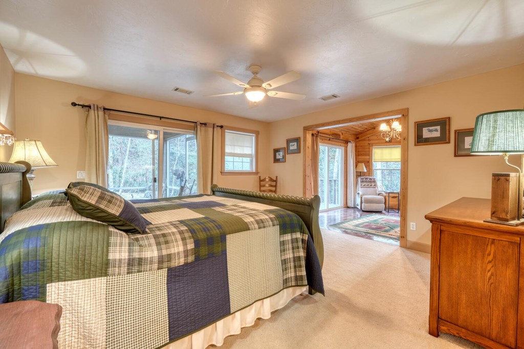 4868 Swallows Creek Road Hiawassee, GA 30546 - Photo 21 of 59 a spacious bedroom with a balcony a bed and a couch