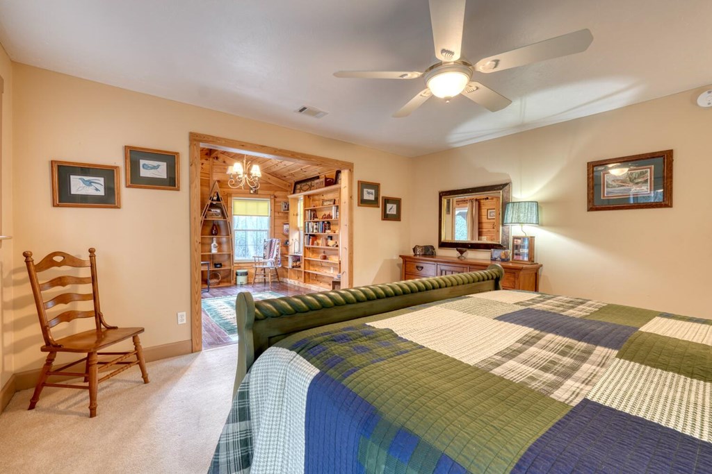 4868 Swallows Creek Road Hiawassee, GA 30546 - Photo 22 of 59 a bedroom with a bed and a chandelier