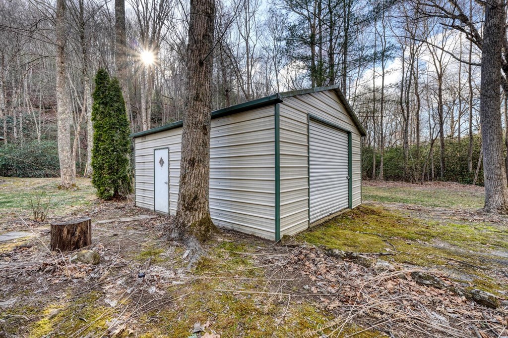4868 Swallows Creek Road Hiawassee, GA 30546 - Photo 53 of 59 a backyard of a house with large trees and barbeque oven