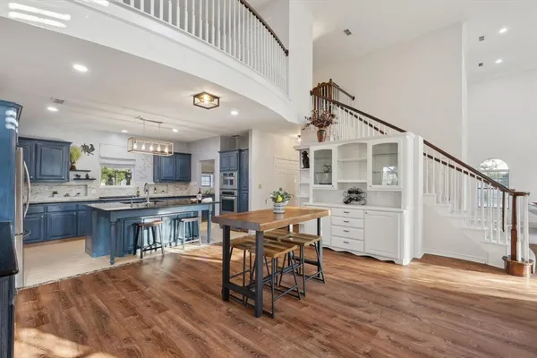 a kitchen with stainless steel appliances a dining table chairs and wooden floor