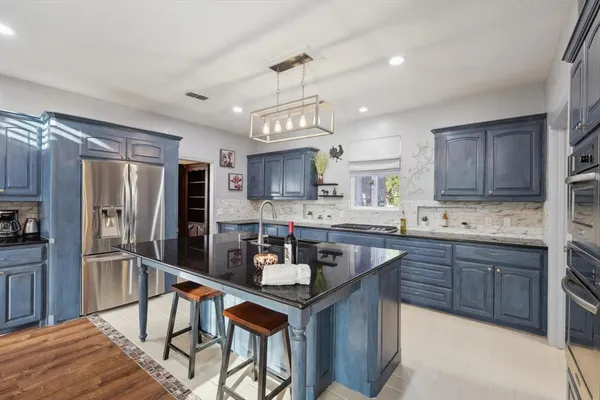 a kitchen with granite countertop a sink stove and refrigerator
