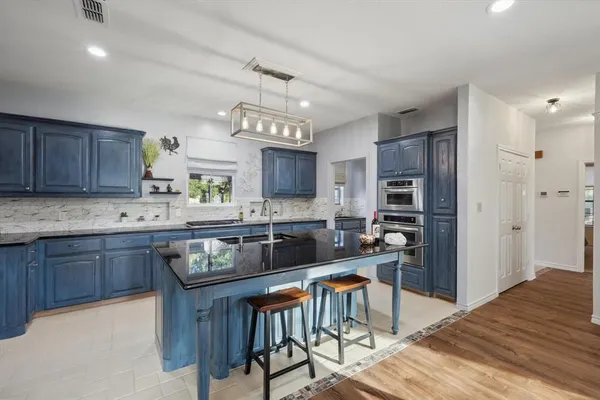 a kitchen with granite countertop a sink and refrigerator