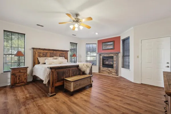 a bedroom with a bed dresser and a fireplace