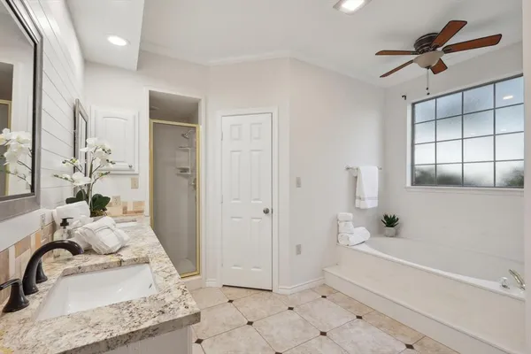 a bathroom with a tub sink and mirror