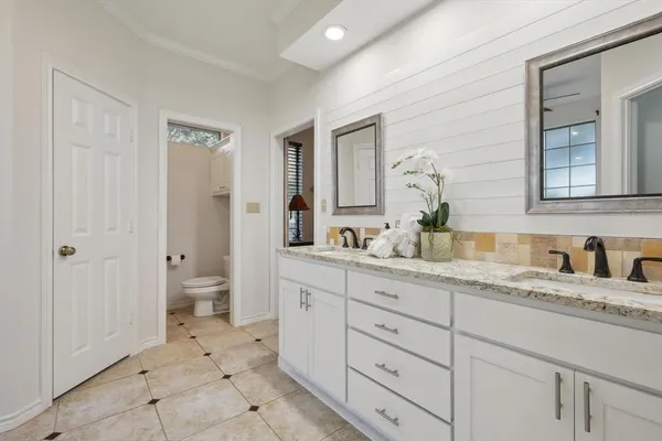 a spacious bathroom with a granite countertop sink mirror and a
