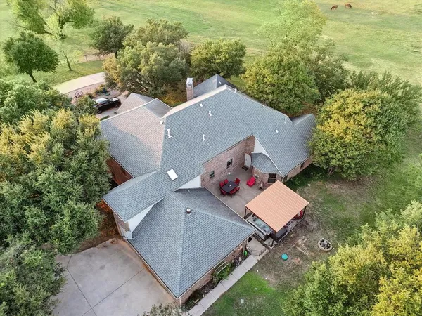 an aerial view of a house with a yard and pool