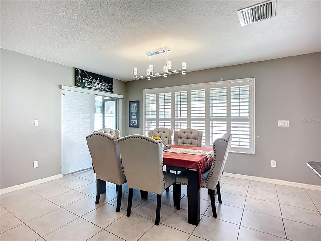 7707 Sunshine Bridge Avenue Gibsonton, FL 33534 - Photo 11 of 33 a view of a dining room with furniture and chandelier