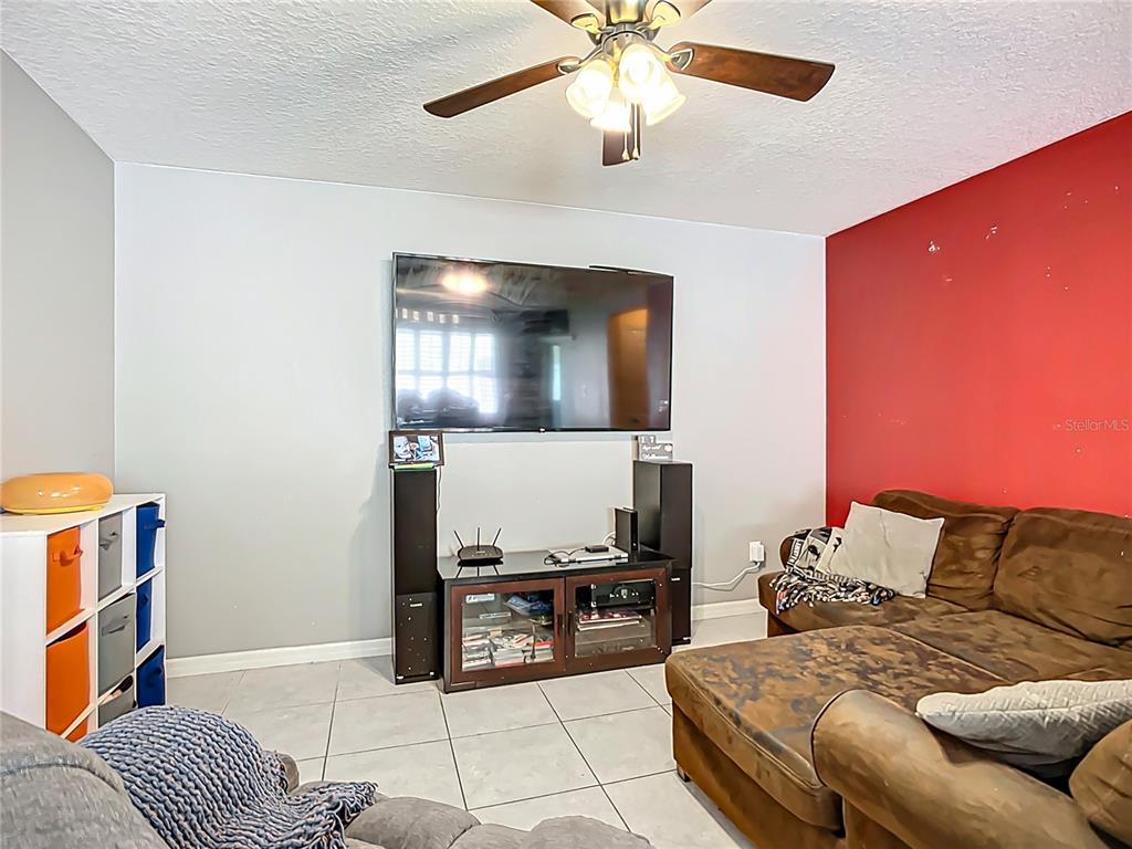 7707 Sunshine Bridge Avenue Gibsonton, FL 33534 - Photo 14 of 33 a living room with a couch and a flat screen tv