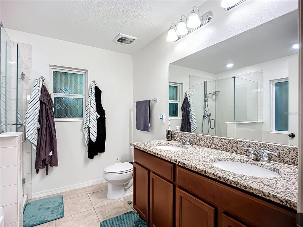 7707 Sunshine Bridge Avenue Gibsonton, FL 33534 - Photo 18 of 33 a bathroom with a granite countertop sink a toilet and a mirror