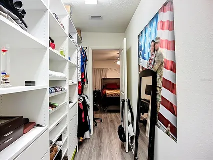 a view of walk in closet with clothes shoes and a mirror