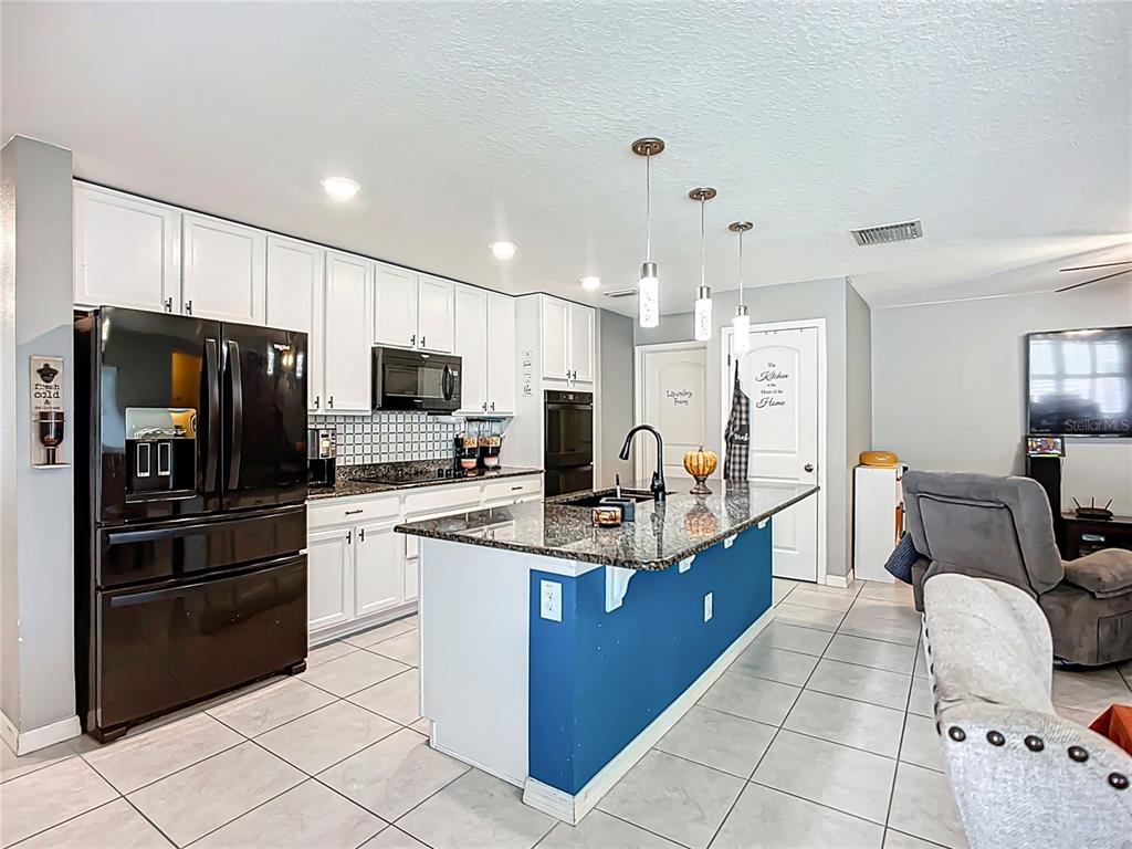 7707 Sunshine Bridge Avenue Gibsonton, FL 33534 - Photo 4 of 33 a kitchen with stainless steel appliances granite countertop a sink stove and refrigerator