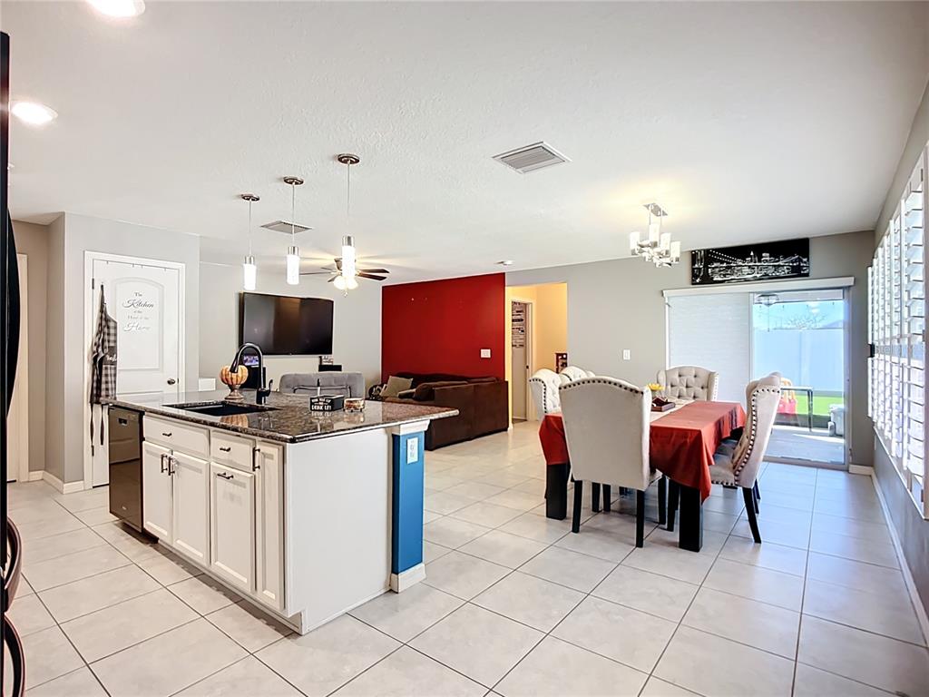 7707 Sunshine Bridge Avenue Gibsonton, FL 33534 - Photo 5 of 33 a kitchen with stainless steel appliances granite countertop a stove top oven a sink dishwasher and a dining table with the kitchen view