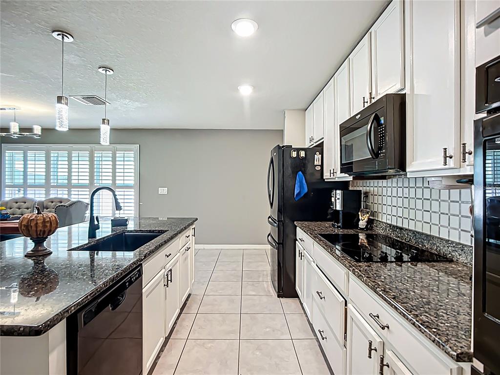 7707 Sunshine Bridge Avenue Gibsonton, FL 33534 - Photo 7 of 33 a kitchen with stainless steel appliances granite countertop a sink stove and refrigerator