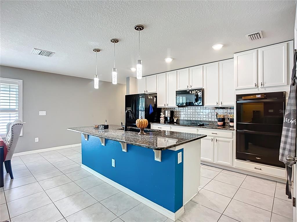 7707 Sunshine Bridge Avenue Gibsonton, FL 33534 - Photo 8 of 33 a kitchen with stainless steel appliances granite countertop a sink a stove top oven and a refrigerator