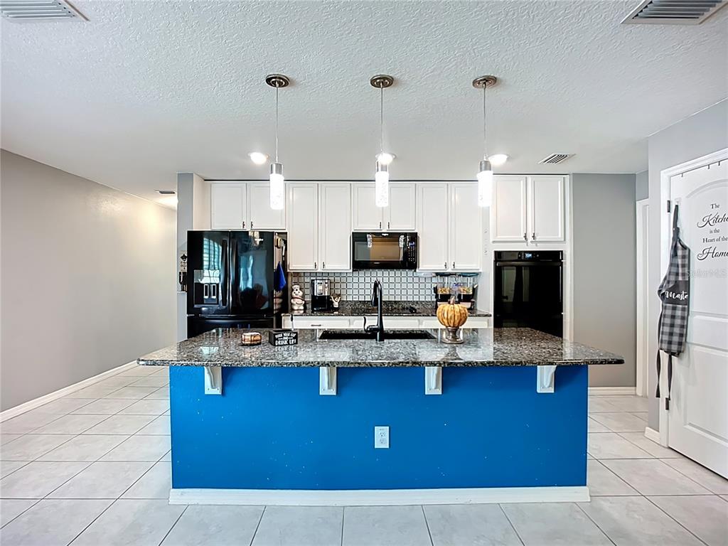 7707 Sunshine Bridge Avenue Gibsonton, FL 33534 - Photo 9 of 33 a kitchen with stainless steel appliances granite countertop a stove a sink dishwasher a refrigerator and a microwave