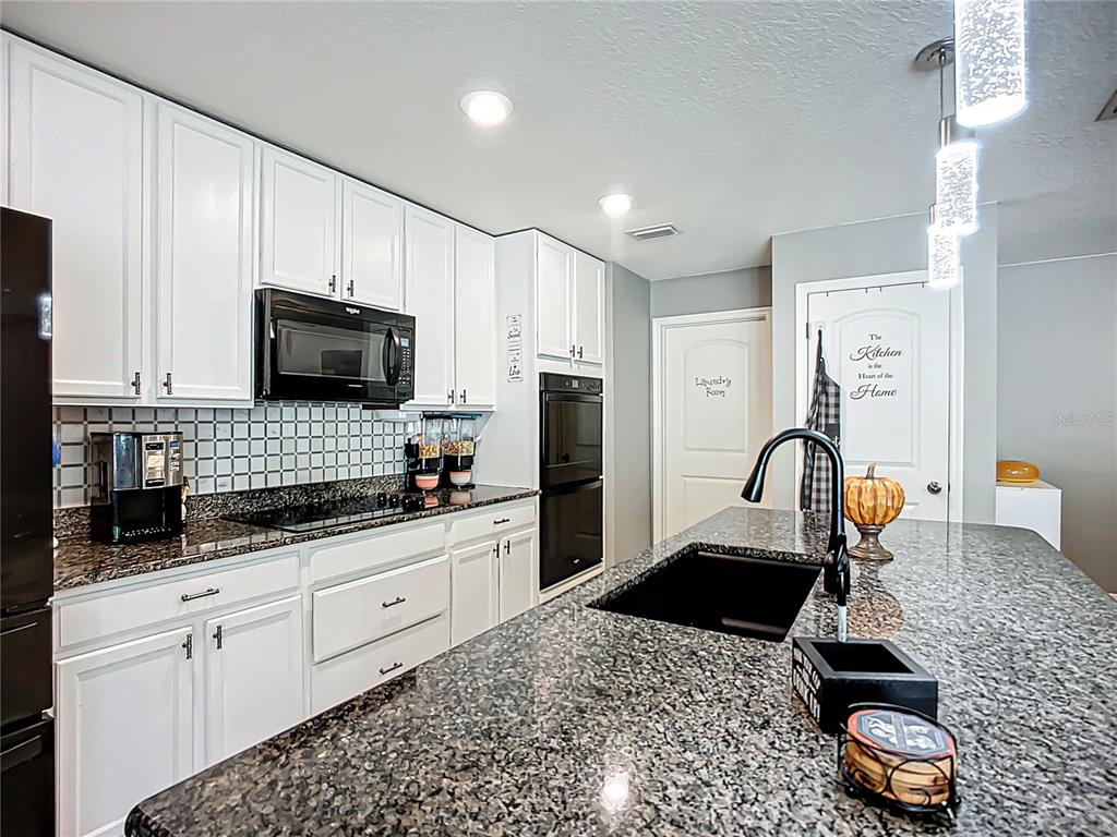 7707 Sunshine Bridge Avenue Gibsonton, FL 33534 - Photo 10 of 33 a kitchen with sink a microwave and cabinets