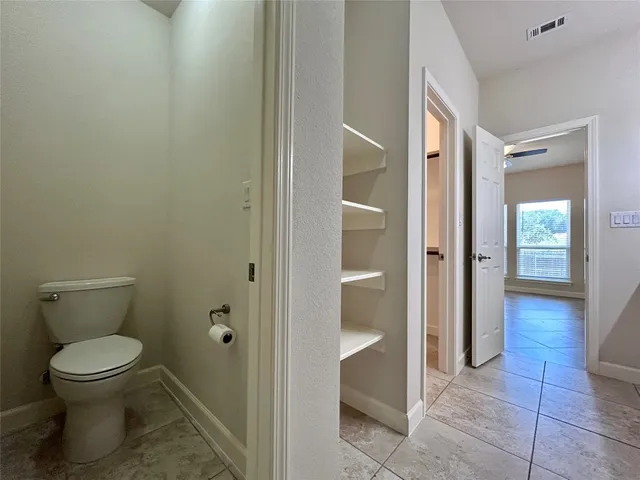 a view of a hallway with a glass door and chandelier fan