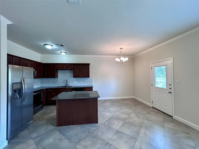 a kitchen with stainless steel appliances granite countertop a stove refrigerator and cabinets