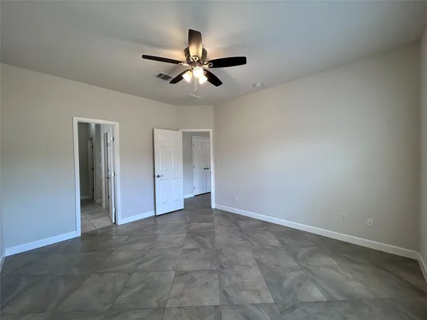 a view of an empty room with a ceiling fan
