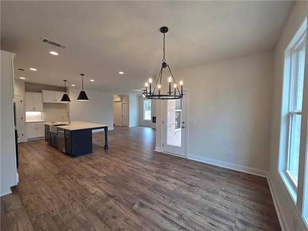 a kitchen with stainless steel appliances wooden floor sink stove and wooden cabinets