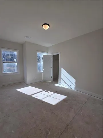 an empty room with projector and windows