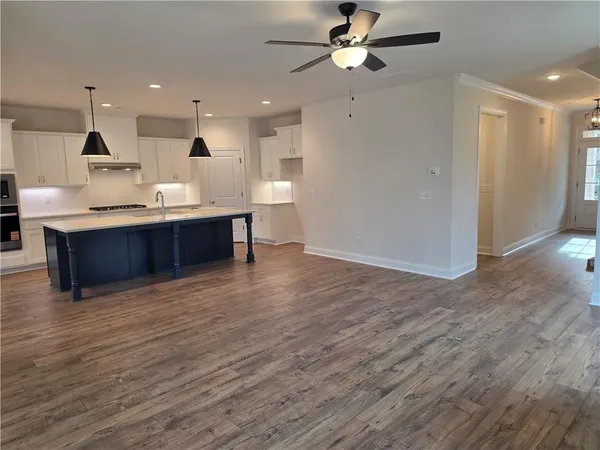 a kitchen with kitchen island a sink stainless steel appliances and wooden floor