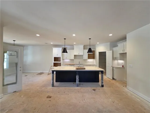 a kitchen with a sink a chandelier and wooden floor