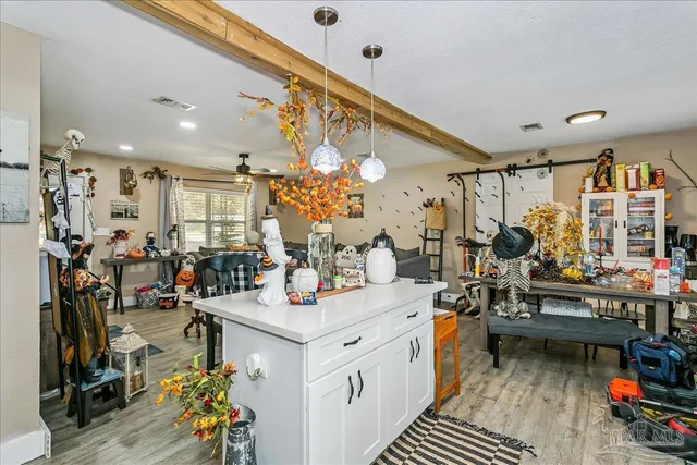 a kitchen that has a lot of white cabinets and stainless steel appliances