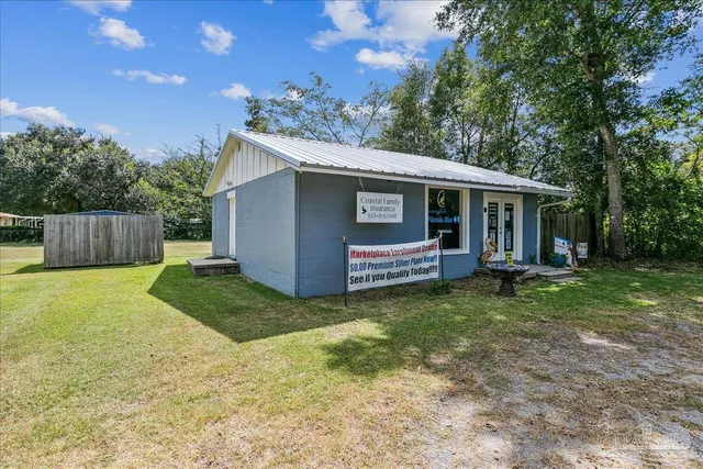 a backyard of a house with barbeque oven and fence