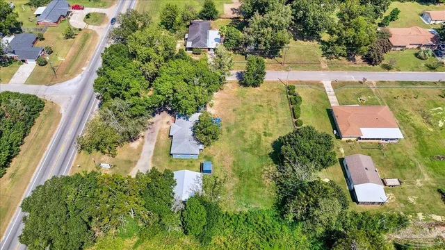 an aerial view of residential house with outdoor space and trees all around