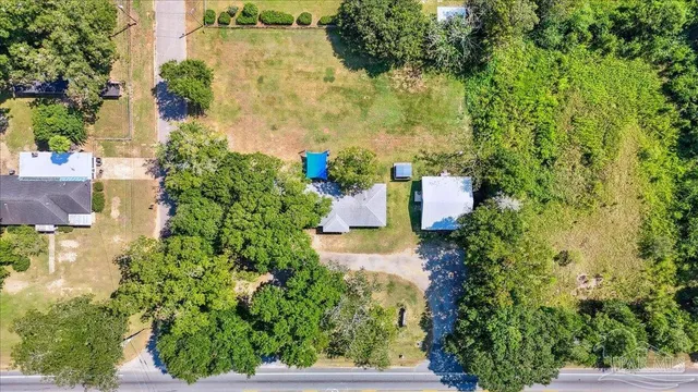 an aerial view of a house with a yard and trees