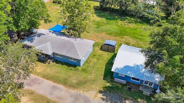 an aerial view of a house with swimming pool and a yard