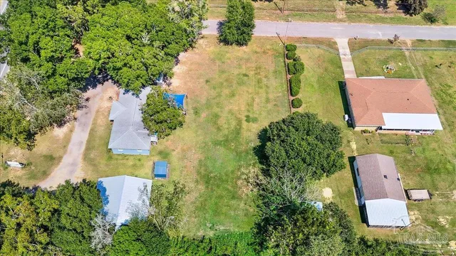 an aerial view of residential house with outdoor space and trees all around