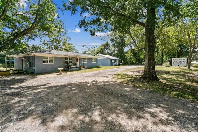 a view of a house with a tree in front of it