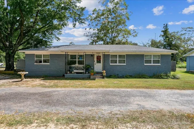 a view of a house with backyard and trees