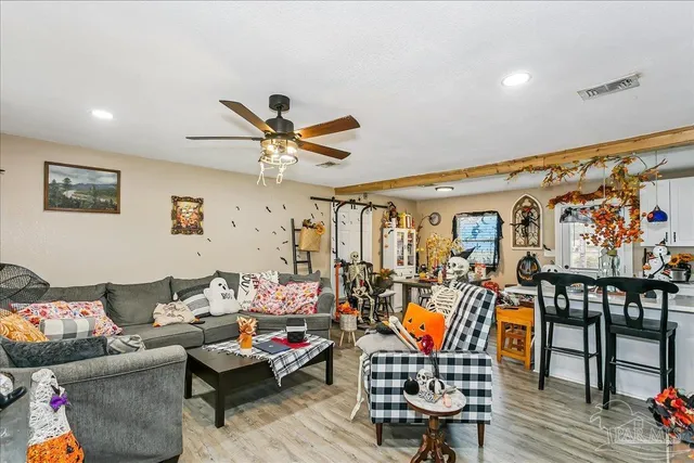 a living room with furniture kitchen view and a large window