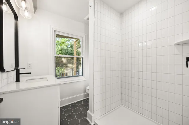 a bathroom with a sink a toilet and a mirror