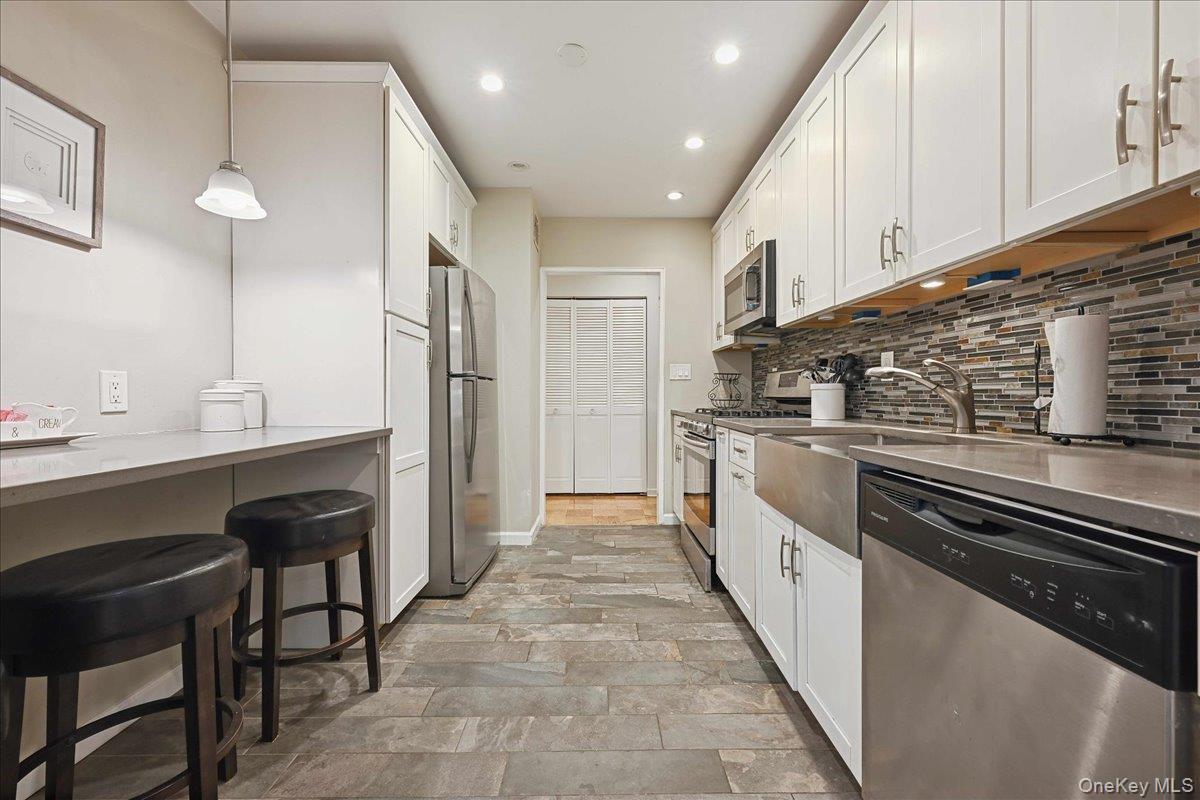 700 Shore Road, Unit 4O Long Beach, NY 11561 - Photo 11 of 42 a large kitchen with stainless steel appliances kitchen island granite countertop a stove a sink and a refrigerator