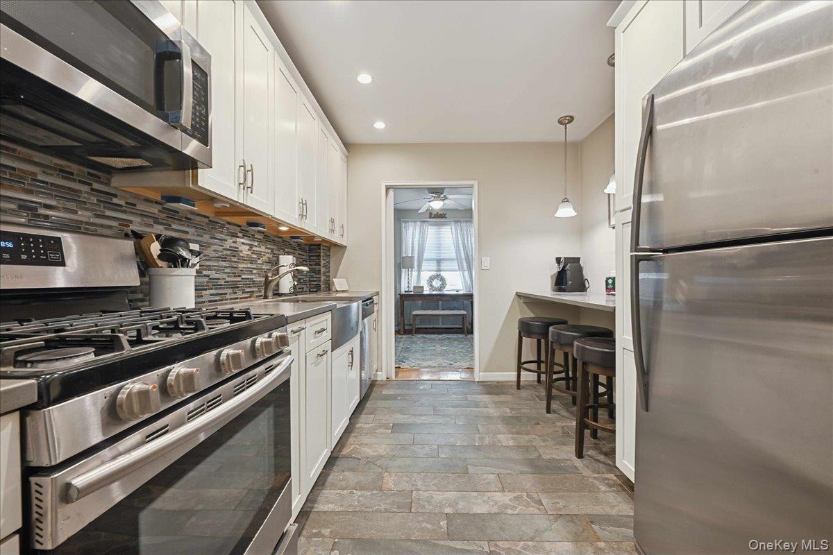 700 Shore Road, Unit 4O Long Beach, NY 11561 - Photo 13 of 42 a kitchen with stainless steel appliances granite countertop a stove and a refrigerator