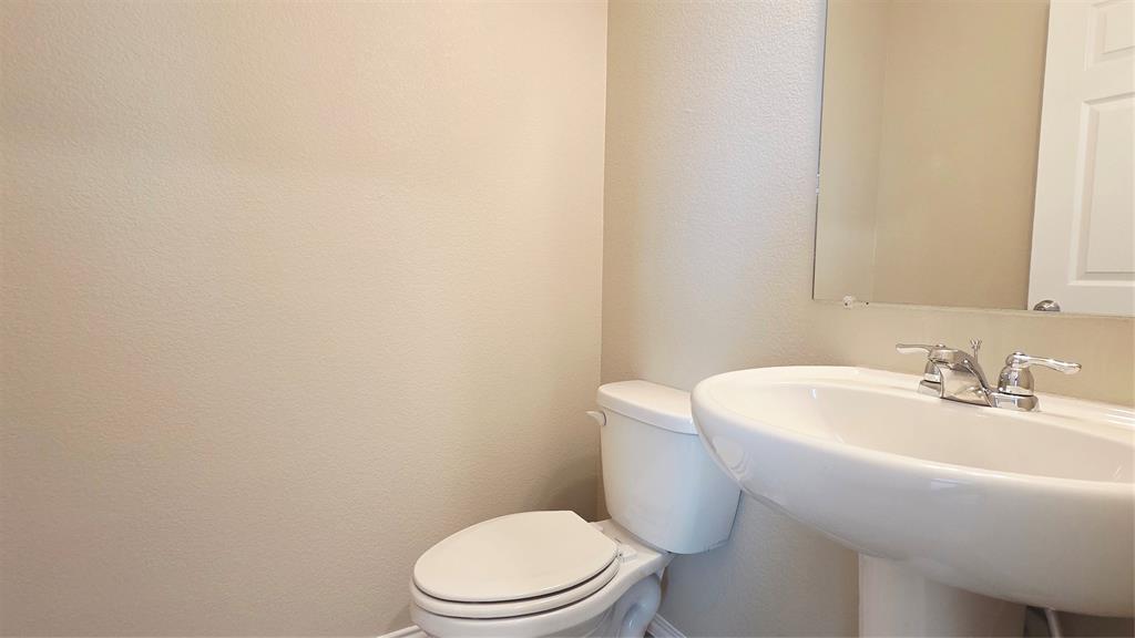 1804 Arcola Court Forney, TX 75126 - Photo 12 of 27 a white toilet sitting next to a white sink