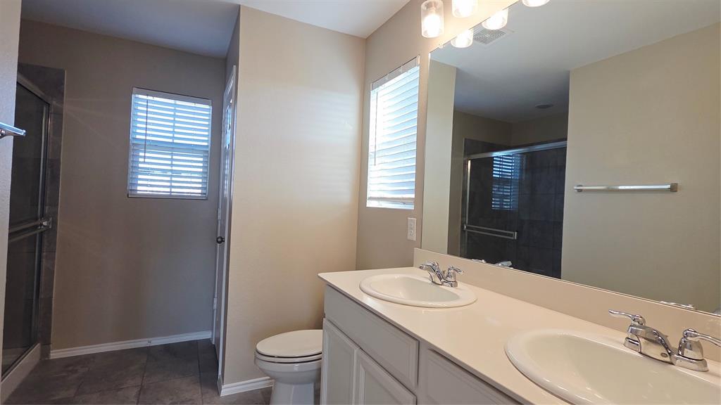 1804 Arcola Court Forney, TX 75126 - Photo 22 of 27 a bathroom with a granite countertop sink toilet and mirror