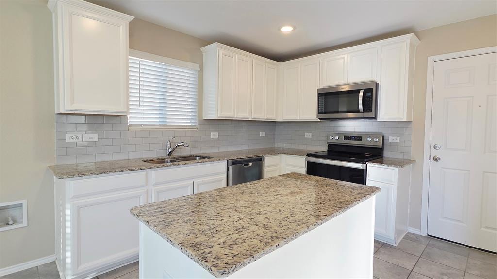 1804 Arcola Court Forney, TX 75126 - Photo 8 of 27 a kitchen with stainless steel appliances granite countertop a sink stove microwave and refrigerator