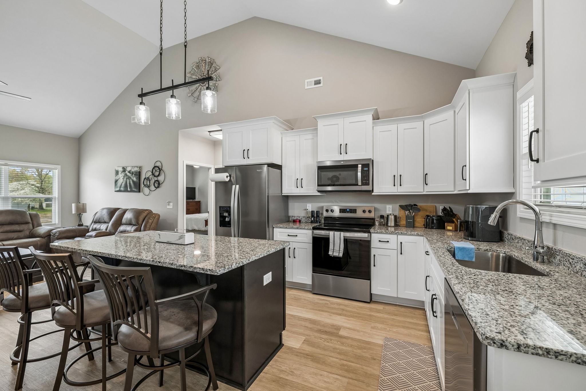 180 Vickers Hill Road Smithville, TN 37166 - Photo 15 of 33 a kitchen with stainless steel appliances granite countertop a sink dishwasher a stove a refrigerator a microwave oven with a dining table and chairs