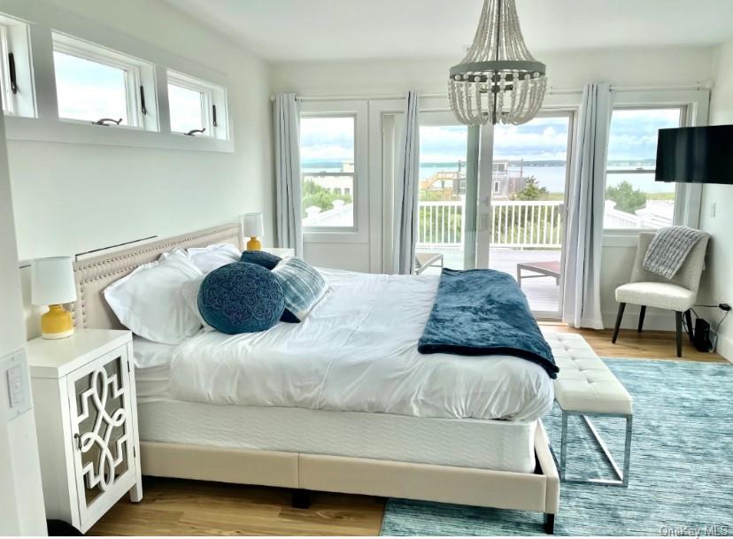 800 Dune Road Westhampton Beach, NY 11978 - Photo 6 of 19 a bedroom with a bed and a chandelier