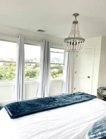 a bedroom with a bed and a chandelier